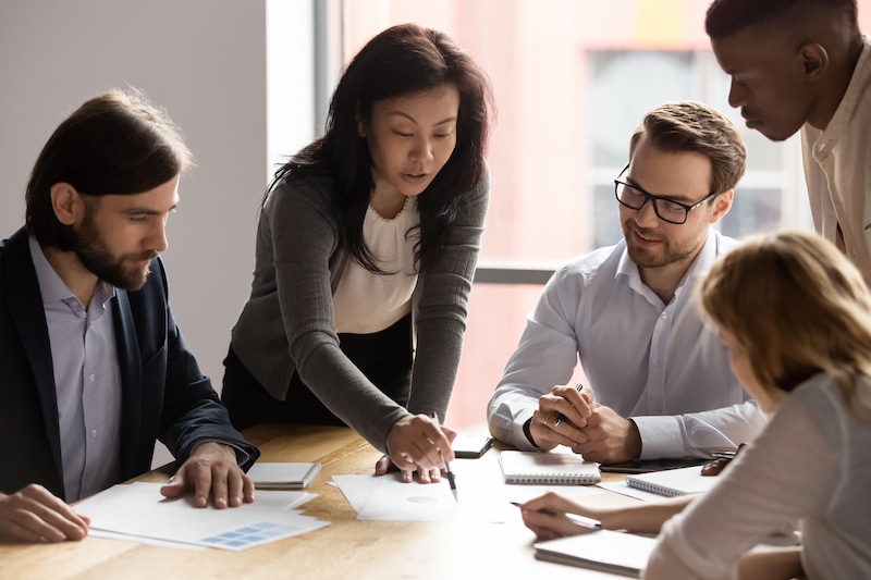 people looking over documents on a table